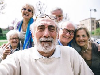 Senioren wohnen zusammen und machen Selfie.