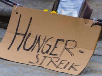 Hungerstreik-Schild mit Blumen.