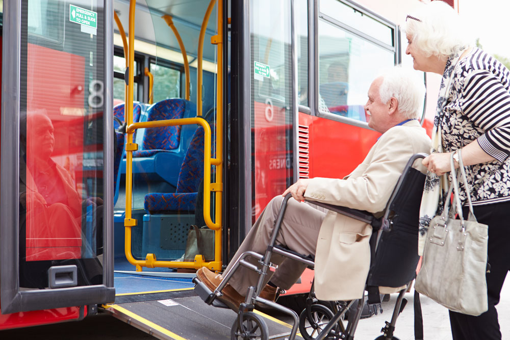 Rollstuhlfahrer nutzt Rampe am Bus.