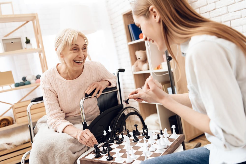 Betreuungskraft spielt Schach mit Seniorin